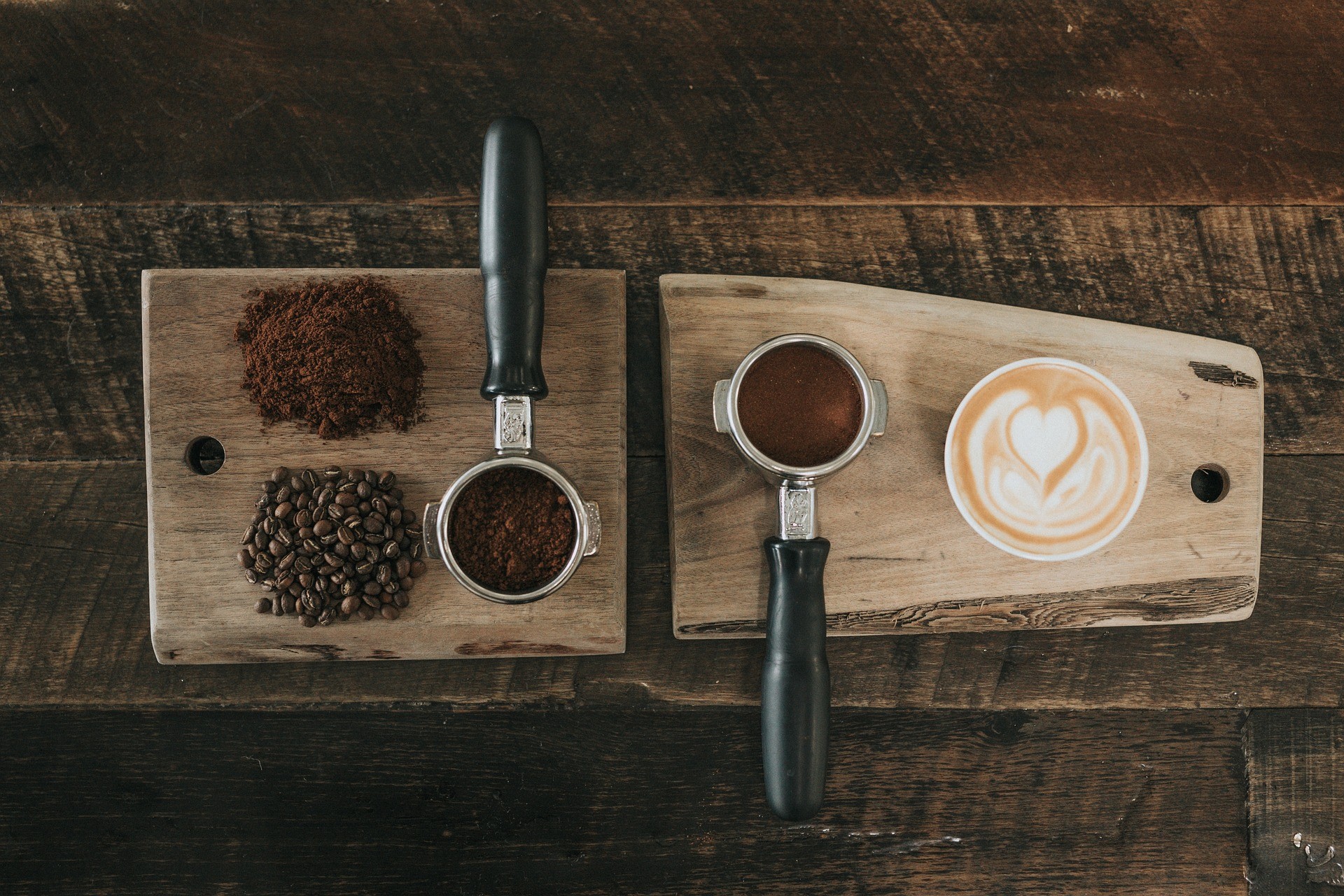Caffè in chicchi e macinato con portafiltro e tazza di espresso su tavolo in legno.