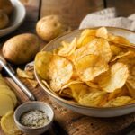 Patatine croccanti fatte in casa con friggitrice ad aria, con patate affettate e sale aromatico.