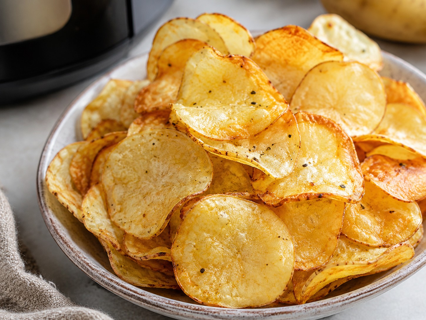 Patatine fritte croccanti cotte in friggitrice ad aria servite in una ciotola.