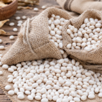 Fagioli Bianchi di Rotonda DOP in sacchetti di juta, con granella bianca sparsa su una superficie intrecciata.