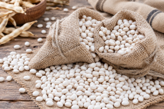 Fagioli Bianchi di Rotonda DOP in sacchetti di juta, con granella bianca sparsa su una superficie intrecciata.