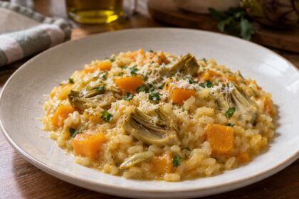 Piatto di risotto con zucca e carciofi cremoso e ben mantecato